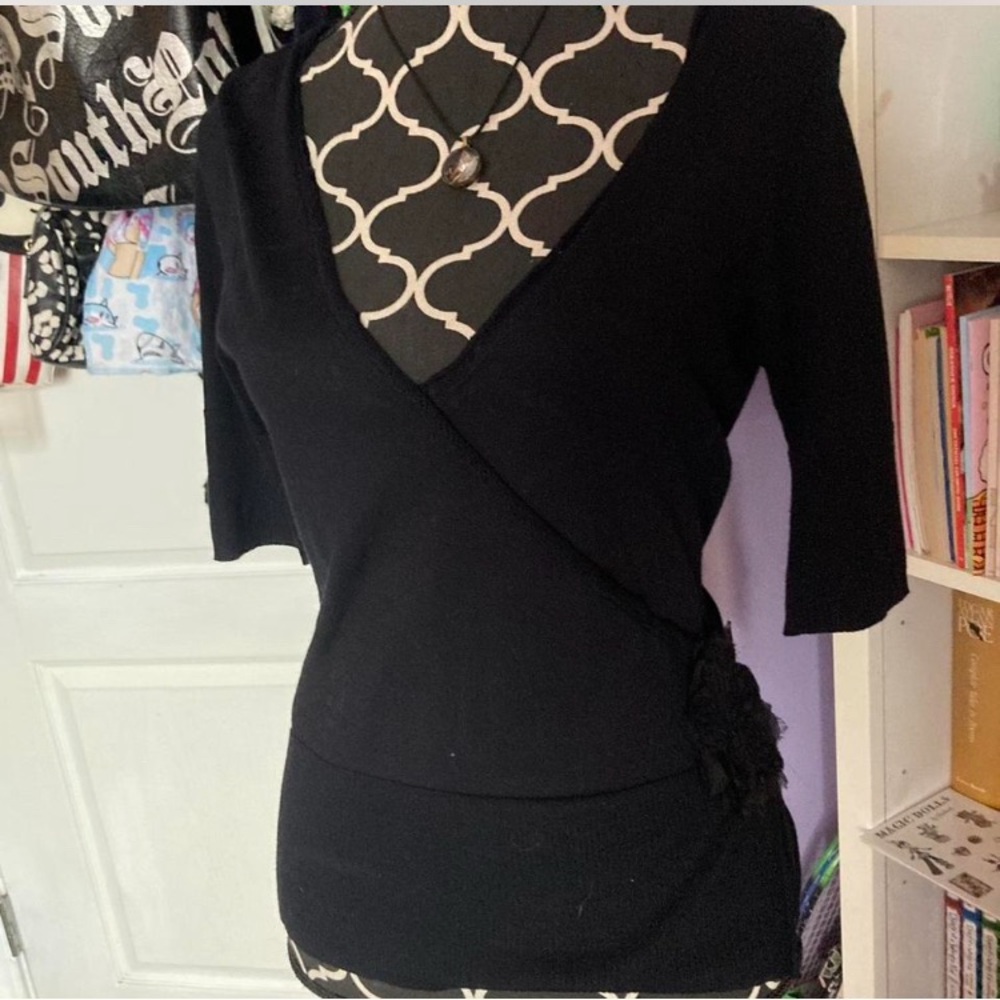 Black fitted 3/4 sleeve top with ruffle flower ruffle tie back for cinched